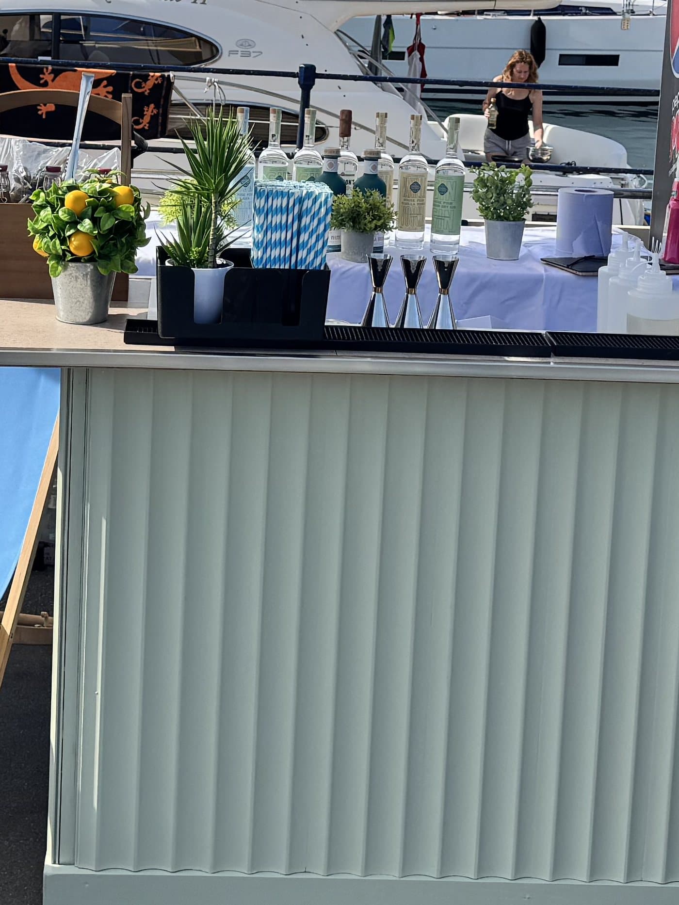 The front of The Dirty Olive bar, with an orange tree, straws and bottles on the counter